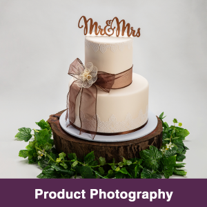 Wedding Cake made by Abbalou Cakes with Mr and Mrs Decal on Top of Cake, brown decorations and sitting on a round of would with green circling the base.